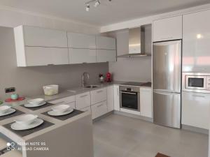 a kitchen with white cabinets and stainless steel appliances at Apartamento Paula in Cee +10 photos
