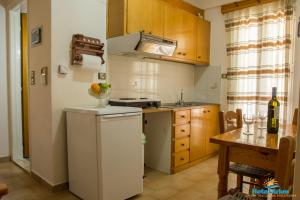 a kitchen with a white refrigerator and a table at Hotel Arion in Nydri