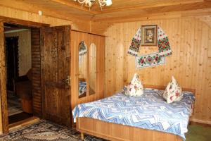 una camera da letto con letto in una camera in legno di У Василини a Yablunytsya