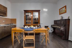 a kitchen with a wooden table and a piano at Penelope Holiday in Rome