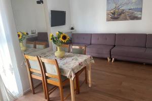 a living room with a table with a vase of flowers on it at Apartament Seagull 30m2 (300 meters to the sea) in Hel