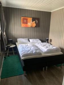 een slaapkamer met een bed met een schilderij aan de muur bij Halsteinsplassen in Surteberg