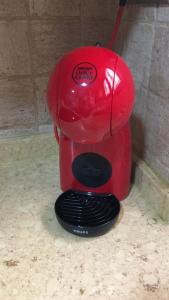 a red coffee maker sitting on the floor at La Burbuja in Almería