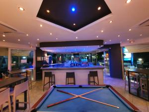 a pool table in a room with a bar at Vivian Hotel in Laganas