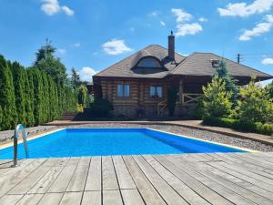 una casa con piscina frente a una casa en Willa-Ranczo Gródek en Gródek Rządowy