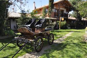 a horse drawn carriage parked in front of a house at Hospedium Hacienda Las Cavas in Olmedo
