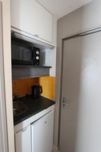 勒帕萊的住宿－Residence Hoteliere Sarah Bernard，一间带水槽和微波炉的小厨房