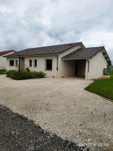 uma casa com uma entrada de cascalho em frente em Gite du patureau em Belleray