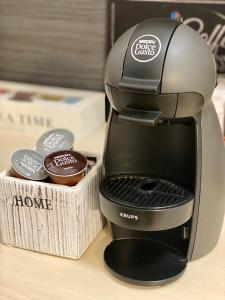 a coffee maker sitting next to a box of cupcakes at City Break Apartment in Visoko