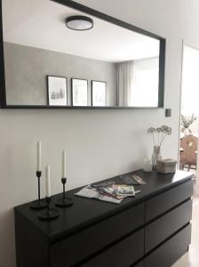 uma cómoda preta com duas velas e um espelho em Apartmán Strnadovy Boudy em Železná Ruda