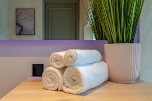 una pila di asciugamani su un tavolo accanto a un vaso di Põlva Maja apartments - contactless check-in a Põlva