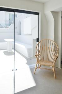 einen Holzstuhl in einem Zimmer mit Fenster in der Unterkunft Princess Mare Hotel - Adults Only in Naxos Chora