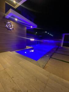 uma piscina num quarto com iluminação azul em Platinum plus mirbat em Salalah