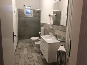 bagno con servizi igienici, lavandino e specchio di Camere AME' a Peschiera del Garda