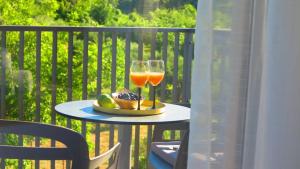 une table avec un verre de vin et une assiette de fruits dans l'établissement Casari rooms & apartments, à Split