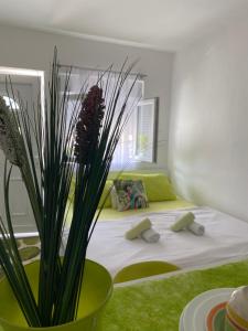 Casa Calda Apartments في ستنيي: غرفة نوم بسرير كبير مع مزهرية خضراء