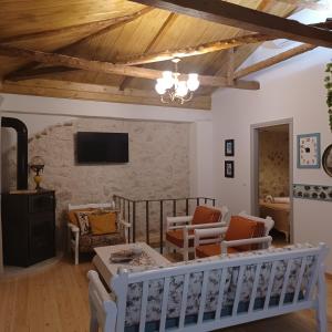 a living room with wooden ceilings and a tv at SYNNEFO - Home in the clouds in Exanthia