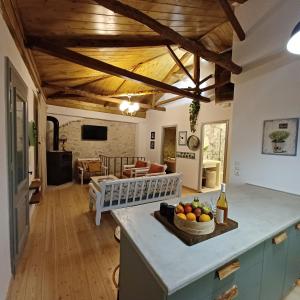 a kitchen and living room with wooden ceilings at SYNNEFO - Home in the clouds in Exanthia