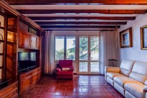 a living room with a couch and a tv at Villa Tamagna - Swimming Pool, Barbeque, Garden in Bevera