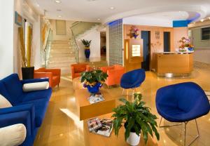 una hall con sedie arancioni e blu e una scala di Hotel Riviera B&B a Misano Adriatico