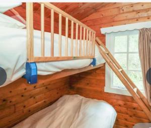 two bunk beds in a wooden room with a window at 3bears Log Cabin Whatstandwell Matlock Derbyshire in Crich