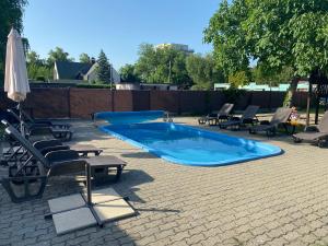 a swimming pool with lounge chairs and an umbrella at MyFlat Diana Family Apartment in Siófok