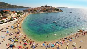 een groep mensen op een strand in het water bij Ivica in Primošten