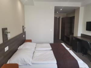 1 dormitorio con 1 cama grande y escritorio en Hotel Tagore, en Balatonfüred