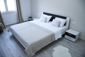 a bedroom with a large bed with white sheets and pillows at Apartment Light in Stobreč