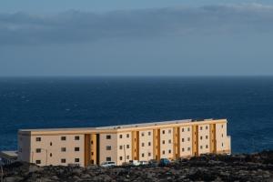 ein Gebäude auf einem Hügel neben dem Meer in der Unterkunft VV Norte y Sur in La Restinga