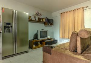 ein Wohnzimmer mit einem Kühlschrank und einem Sofa in der Unterkunft Apartamento Completo de 2 quartos em Gramado in Gramado