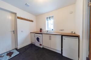 a laundry room with a sink and a washing machine at 8 Person-Luxury-FamilyFriendly-PetFriendly-Hot Tub in Hawick