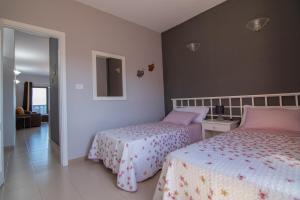 1 Schlafzimmer mit 2 Betten und einem Spiegel in der Unterkunft VV Norte y Sur in La Restinga