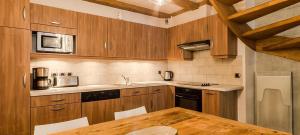 eine Küche mit Holzschränken und einem Holztisch in der Unterkunft Appart 6 pers centre Le Praz - Los Robles in Courchevel