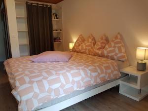 グレヘンにあるChalet Schneevogulのベッドルーム1室(ピンクと白の掛け布団付きのベッド1台付)