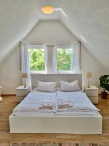 バート・ヴィンツハイムにあるKaruna Hausのベッドルーム1室(大きな白いベッド1台、窓2つ付)