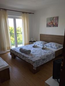 a bedroom with a bed and a large window at Apartment Fugosic in Šilo