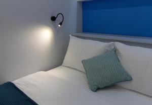 a bed with a blue headboard and a blue pillow at Luxury studio на Пушкина in Alekseyevka