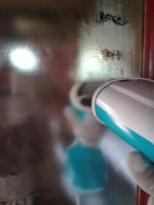 a person holding a toothbrush in front of a mirror at Chalés City Camael in São Thomé das Letras