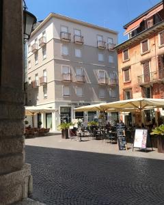 un edificio con tavoli e ombrelloni di fronte ad esso di Hotel Europa a Verona