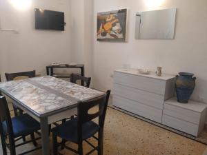 une salle à manger avec une table et une commode dans l'établissement Maison Mafalda, à Surbo