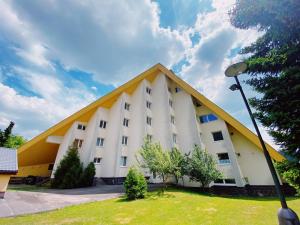 a large white building with a yellow roof at The Legits Apartments in Donovaly