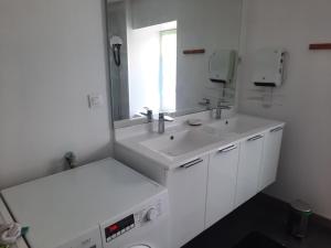 a white bathroom with two sinks and a mirror at Appartement très spacieux 4 chambres 6 couchages in Noidans-le-Ferroux