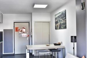 a dining room with a white table and stools at Cosenza Luxury Apartment in Cosenza