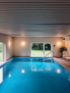 a large swimming pool with blue water in a house at Ferienwohnung Toskana mit Schwimmbad und Sauna in Bad Bergzabern