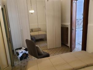 Cette chambre comprend un lit, une chaise et un miroir. dans l'établissement Maison Mafalda, à Surbo