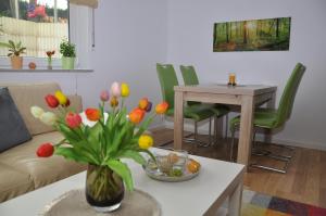 uma sala de estar com um vaso de flores sobre uma mesa em Ferienwohnung Schöne Zeit em Gedern