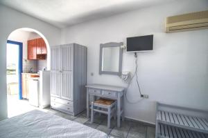 a bedroom with a table and a mirror on the wall at Sunset in Agios Prokopios