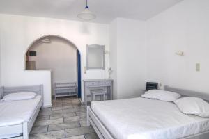 a bedroom with two beds and a mirror at Sunset in Agios Prokopios