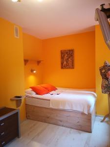 una camera da letto con pareti arancioni e un letto interno di Pod Gadającym Kotem a Długopole-Zdrój